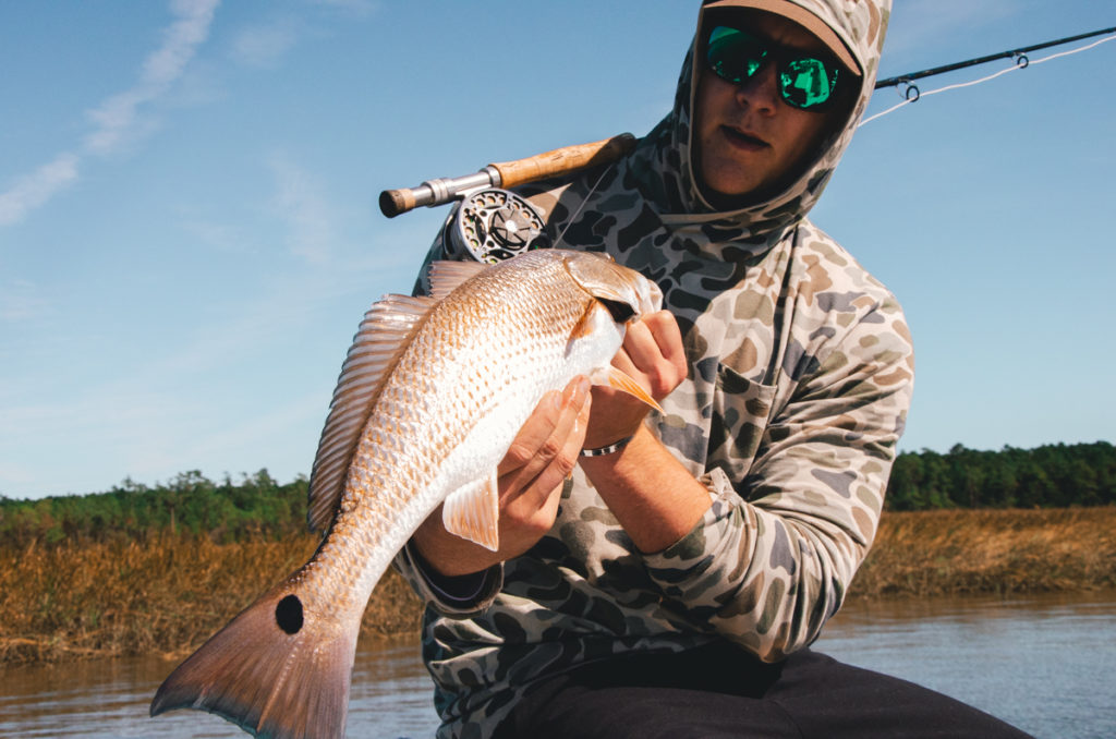 Red Fish On Fly Held By Client