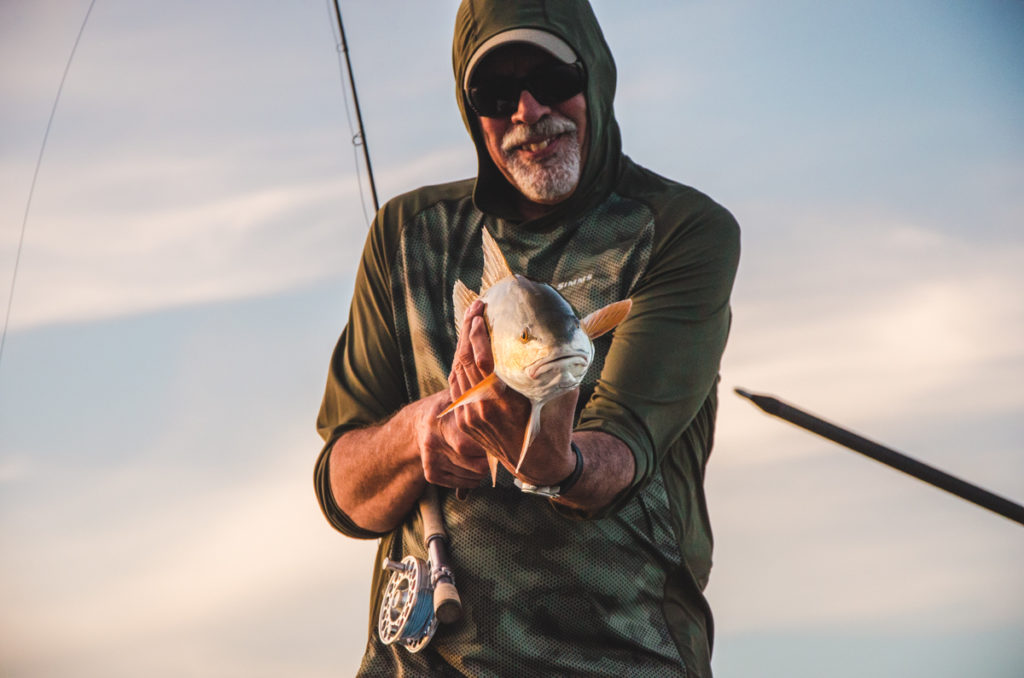 Sweetwater Flood Tide Client Standing Front Bow with Redfish and Fly Rod